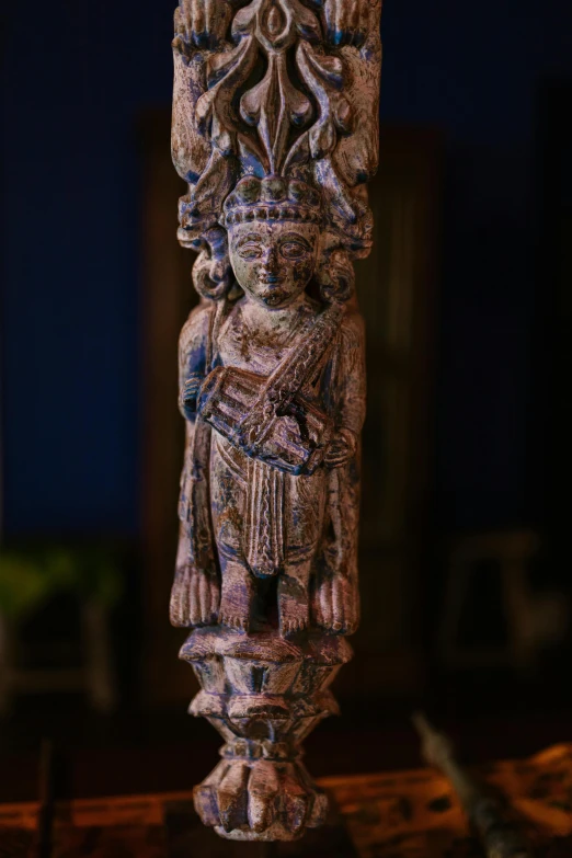 a statue sitting on top of a wooden table, long trunk holding a wand, highly detailed carvings, shot with sony alpha, hindu aesthetic