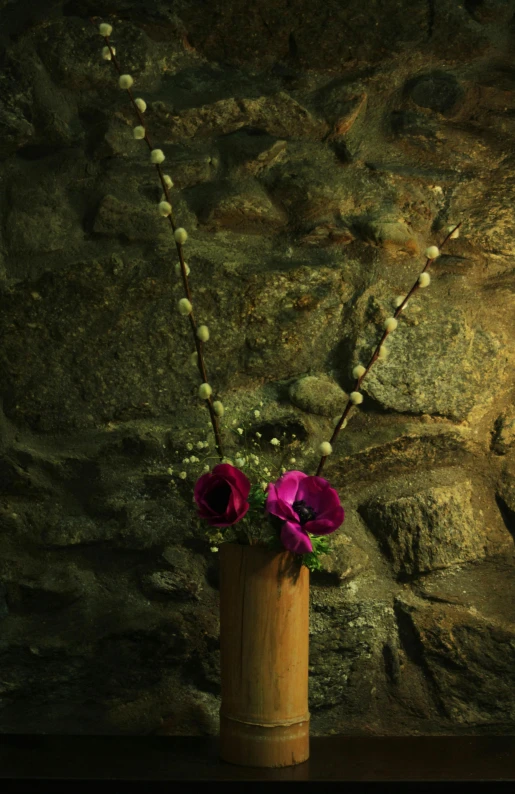 a vase with flowers on a table in front of a stone wall, by Doug Ohlson, romanticism, very moody lighting, on the altar, brown and magenta color scheme, kyoto inspired