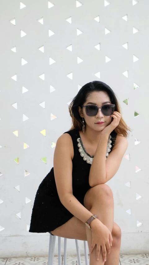 a woman sitting on top of a metal stool, by Cherryl Fountain, pexels contest winner, minimalism, with mirrorshades sunglasses, gif, low quality photo, faridah malik