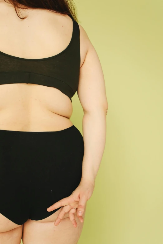 a woman in black underwear standing in front of a green wall, trending on pexels, morbidly obese, wearing a crop top, swollen muscles, lined up horizontally