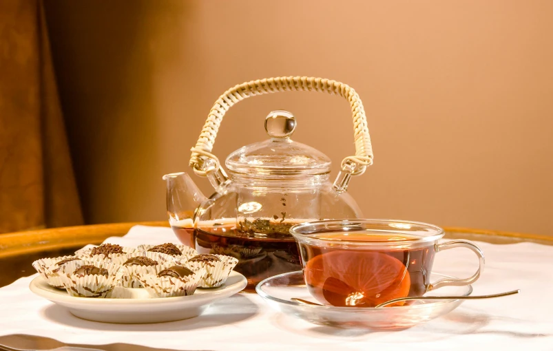 a tea pot sitting on top of a table next to a cup of tea, a still life, inspired by Charles Le Roux, pexels, arabesque, snacks, brown, square, thumbnail