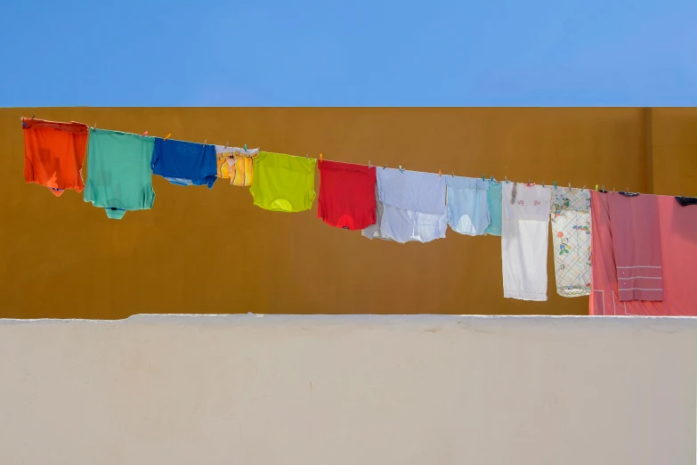 clothes hanging out to dry on a clothes line, by Alison Geissler, pexels contest winner, postminimalism, ocher and turquoise colors, colorful hyperrealism, archival pigment print, chartreuse and orange and cyan