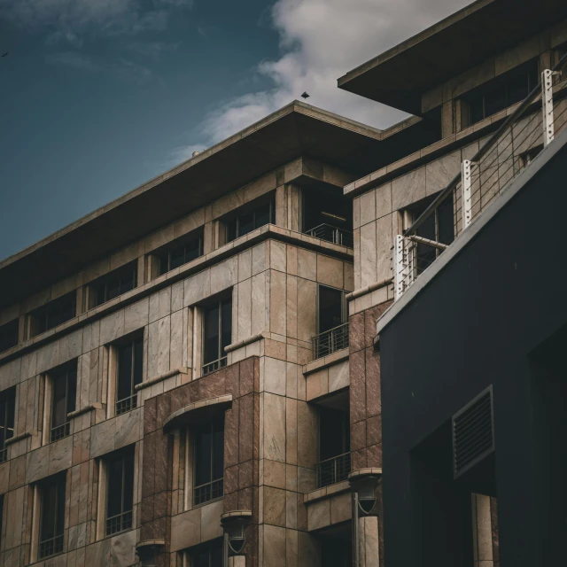 a tall building sitting next to a tall building, a photo, pexels contest winner, brutalism, beige and dark atmosphere, classicism style, nepali architecture buildings, today\'s featured photograph 4k