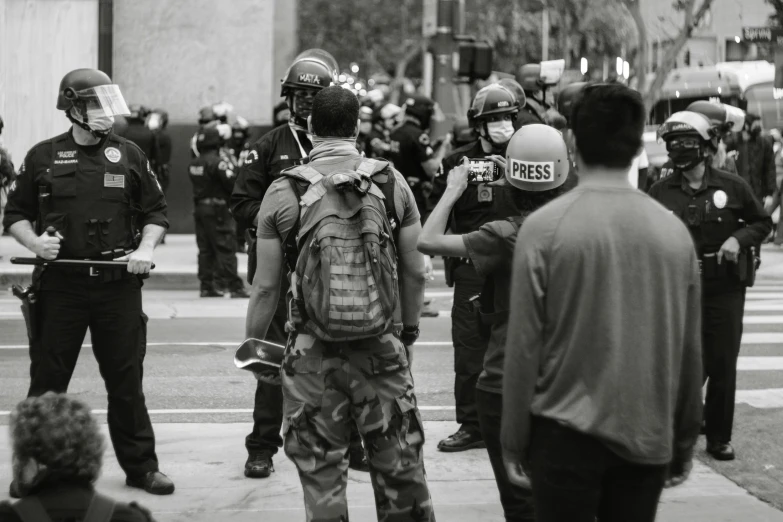 a group of people that are standing in the street, a black and white photo, pexels, excessivism, wearing tactical gear, los angeles ca, police calling for back up, a photo of a man