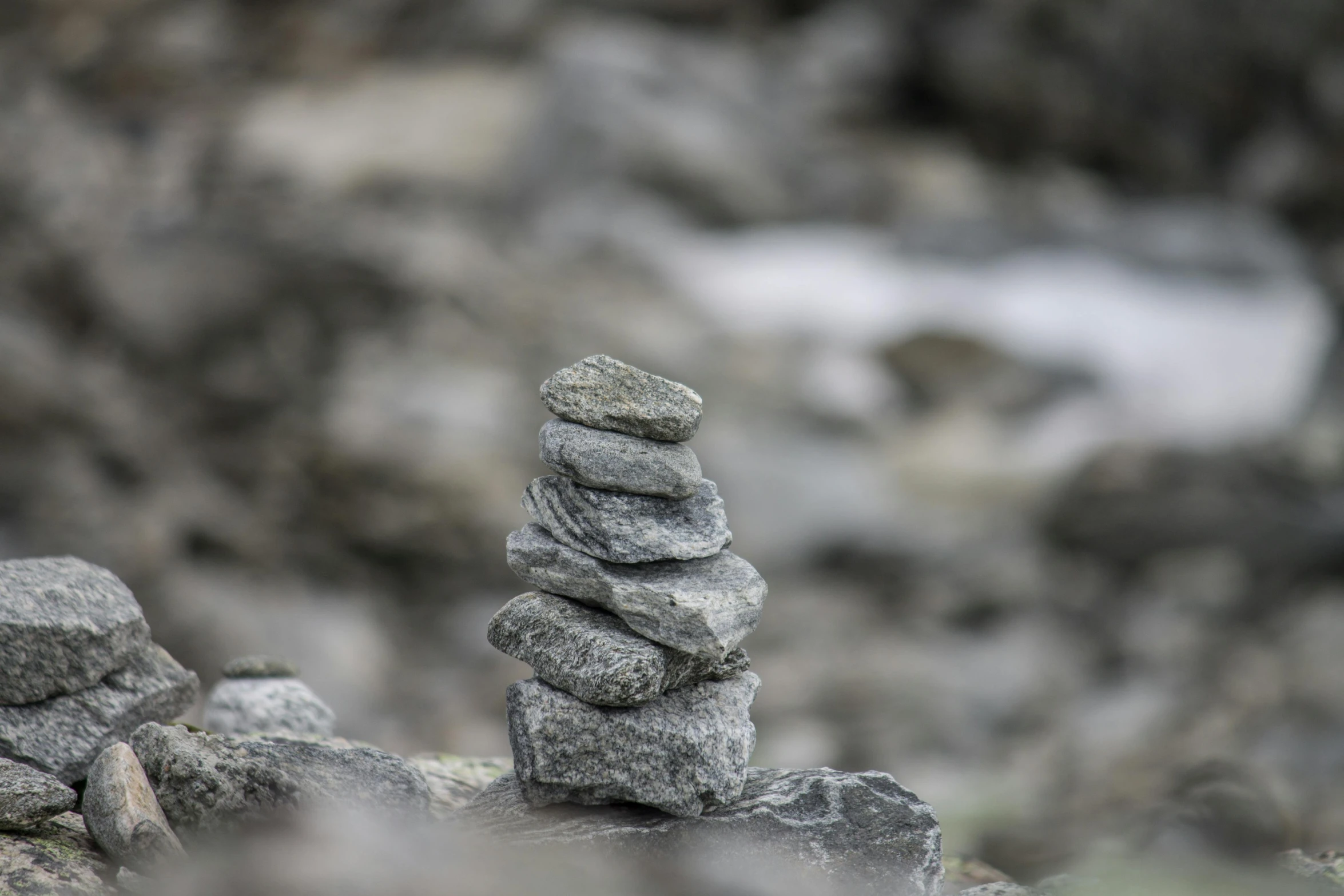 a pile of rocks sitting on top of a rocky hillside, inspired by Andy Goldsworthy, unsplash, land art, grey, small, totem pole, inuit