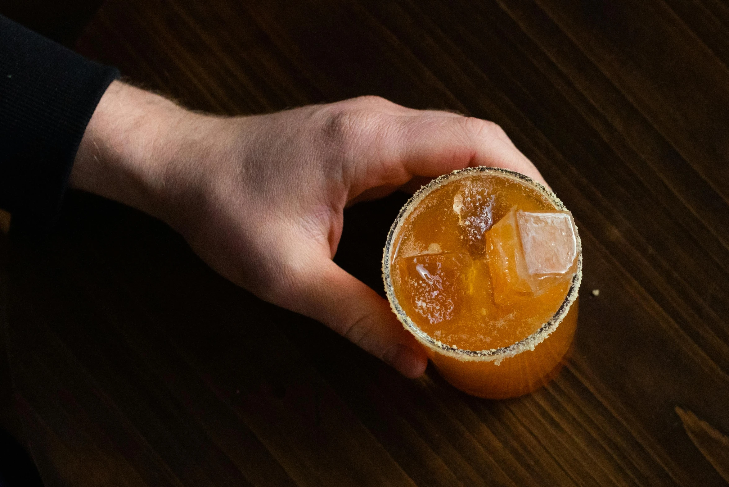 an orange juice cocktail held in a hand