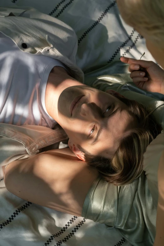 a man laying on top of a bed next to a woman, a portrait, trending on pexels, photorealism, in the sun, jodie whittaker, close-up from above, midsommar - t