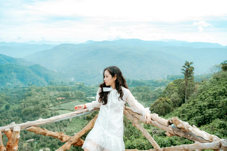 a woman standing on top of a wooden fence, inspired by Ni Yuanlu, pexels contest winner, sumatraism, wearing white dress, mountainside, handsome girl, 8 k. filling of the view