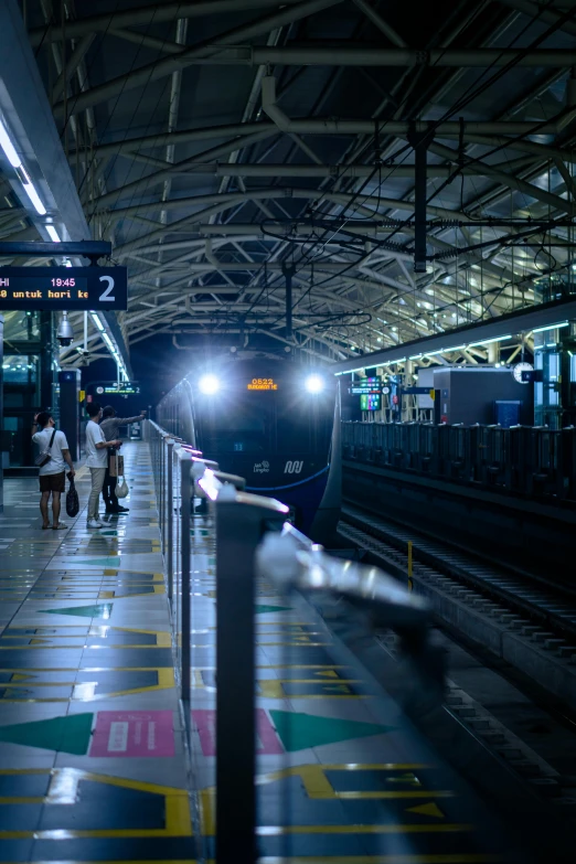 a train pulling into a train station at night, by Joze Ciuha, unsplash, in sci - fi mumbai, avatar image