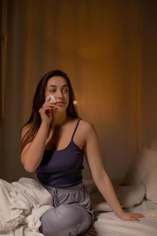 a woman sitting on a bed brushing her teeth, by Julia Pishtar, trending on pexels, happening, fireball lighting her face, a plaster on her cheek, product shot, her face in discs