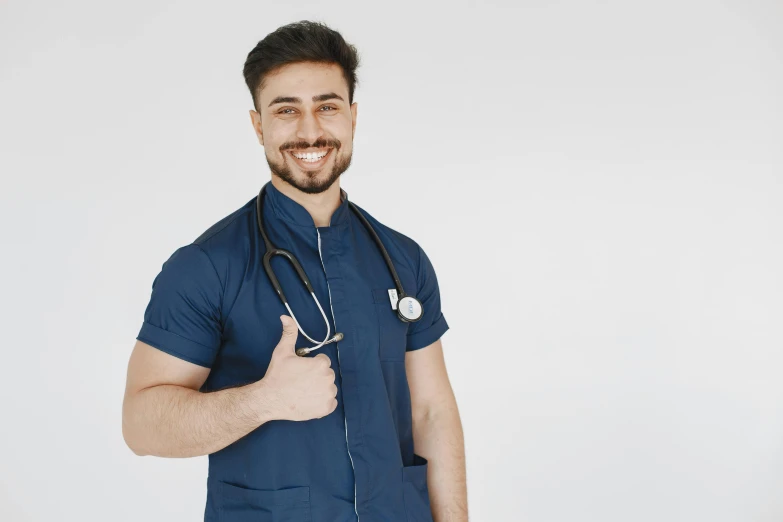 a smiling male doctor in a blue shirt with a stethoscope on his neck