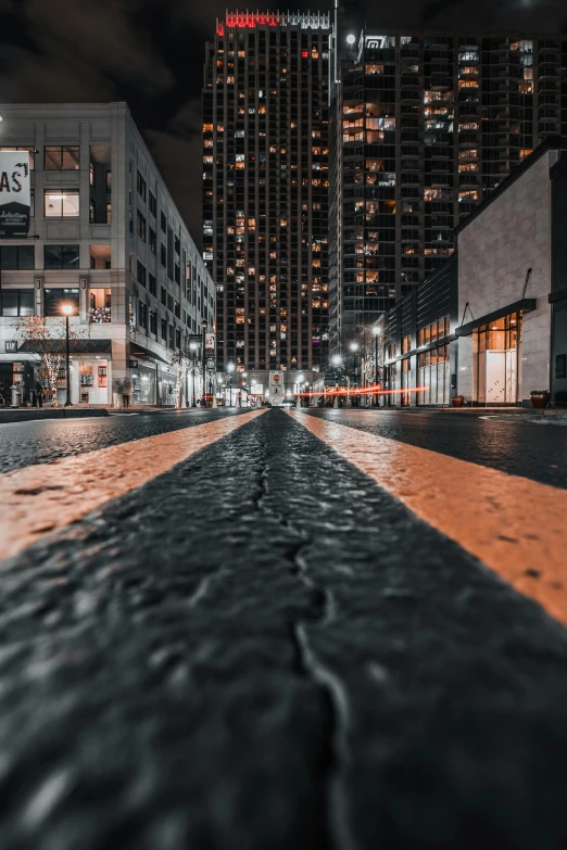 a dark city street lined with tall buildings at night