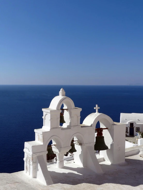 a white church sitting on top of a cliff next to the ocean, slide show, square, greek ethnicity, iconic shot