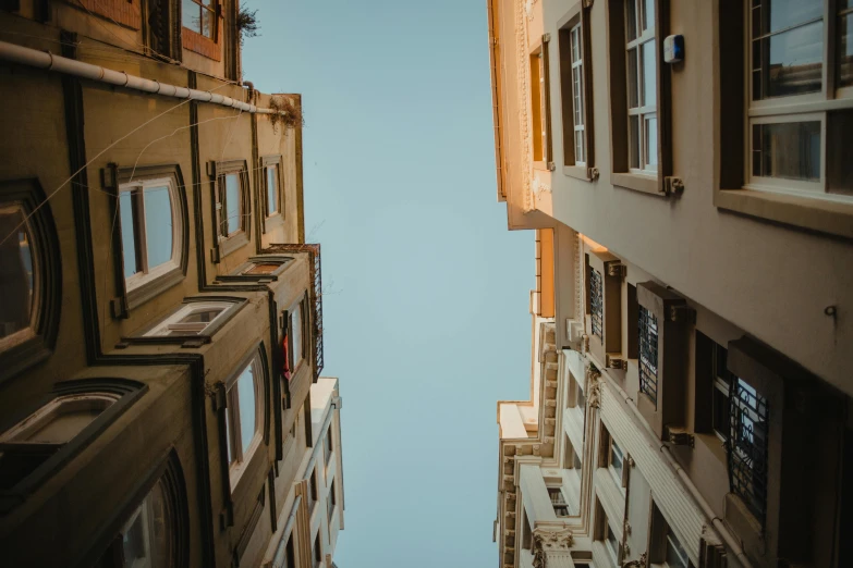 a couple of tall buildings next to each other, a picture, pexels contest winner, clear sky above, alleys, istanbul, looking upwards