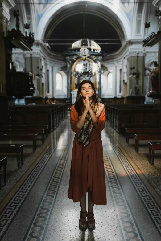 a woman in a brown dress standing in a church, pexels contest winner, buenos aires, praying meditating, square, a young asian woman