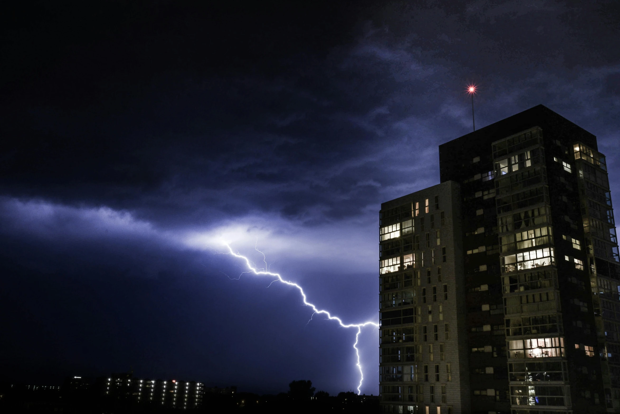 a large building with a lightning bolt above it and the sky in front of it