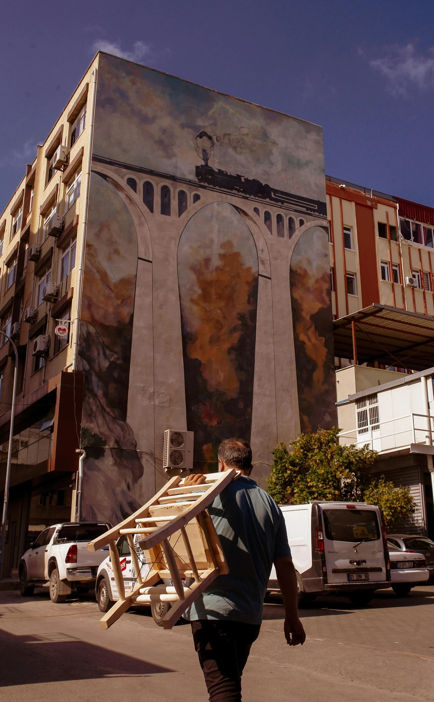 a man walking down a street past a tall building, inspired by Ricardo Bofill, street art, under repairs, archive photo, weta studio, chile