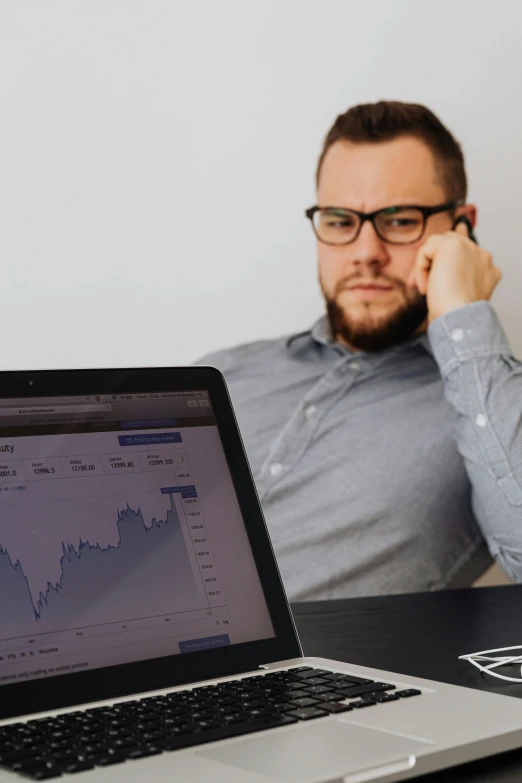 a man sitting in front of a laptop computer, trending on unsplash, renaissance, graphs, realistic », frowning, plain background