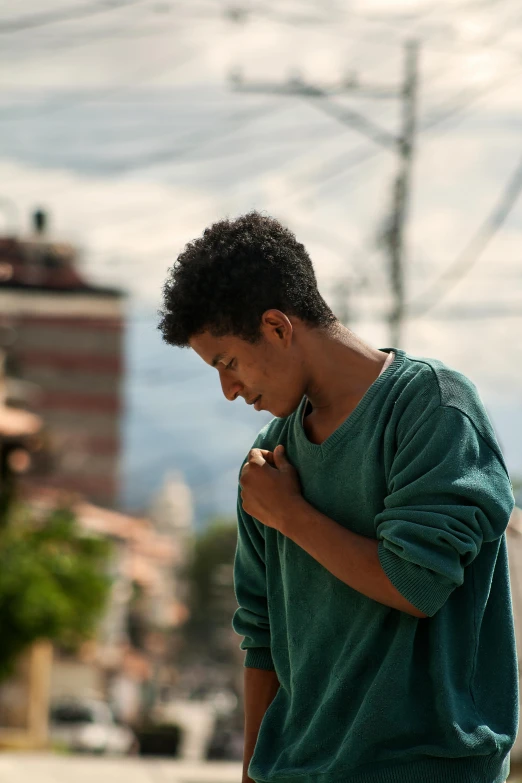 a man stands outside looking down at his cellphone