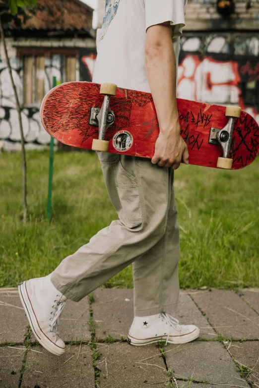 a man walking with a skateboard in his hand, trending on pexels, graffiti, red shirt brown pants, scribbled, curated collections, aged 13