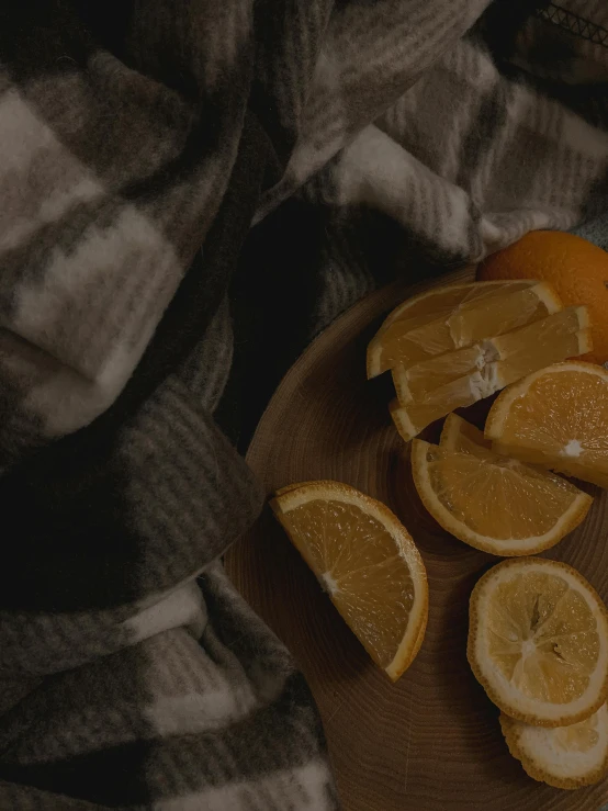 a wooden cutting board topped with sliced oranges, a still life, by Carey Morris, unsplash contest winner, covered with blanket, movie still 8 k, eating, dark and beige atmosphere