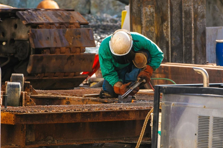 a man working on a piece of metal, by Yasushi Sugiyama, pexels contest winner, shipyard, brown, thumbnail, construction site