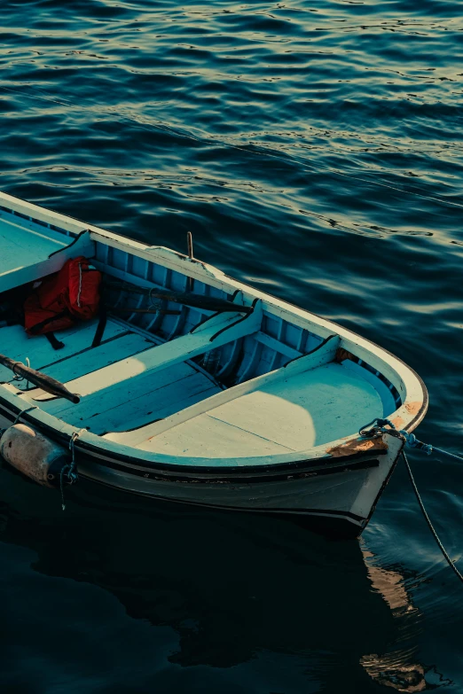 a small boat floating on top of a body of water, dark blue water, on a boat