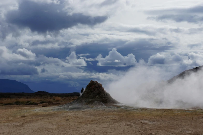 three people standing at the top of a mountain in the desert