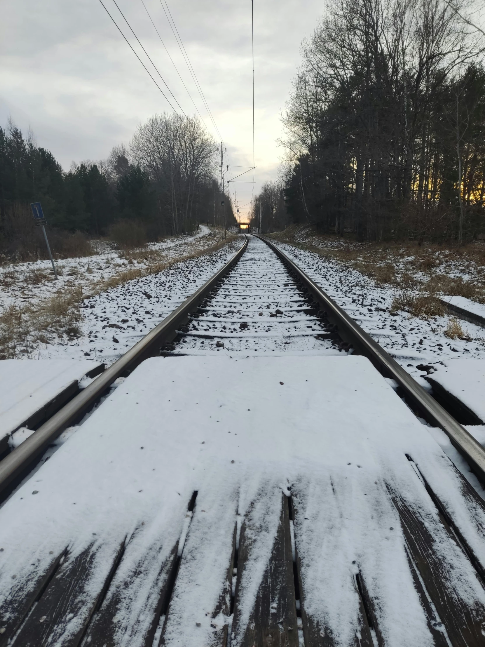 a train traveling down train tracks covered in snow, an album cover, unsplash, realism, low quality photo, trip to legnica, thumbnail, phone photo