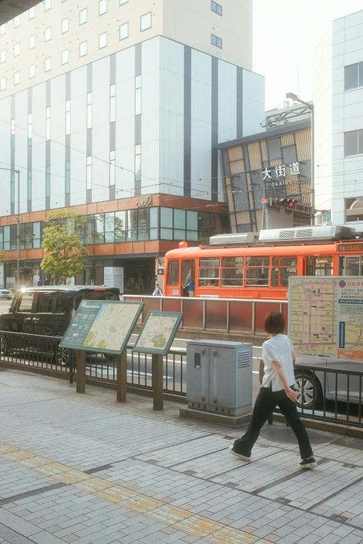 a man walking down a sidewalk next to a train, a digital rendering, inspired by Tōshi Yoshida, unsplash, sōsaku hanga, research complex, street tram, 1990 photograph, exterior view