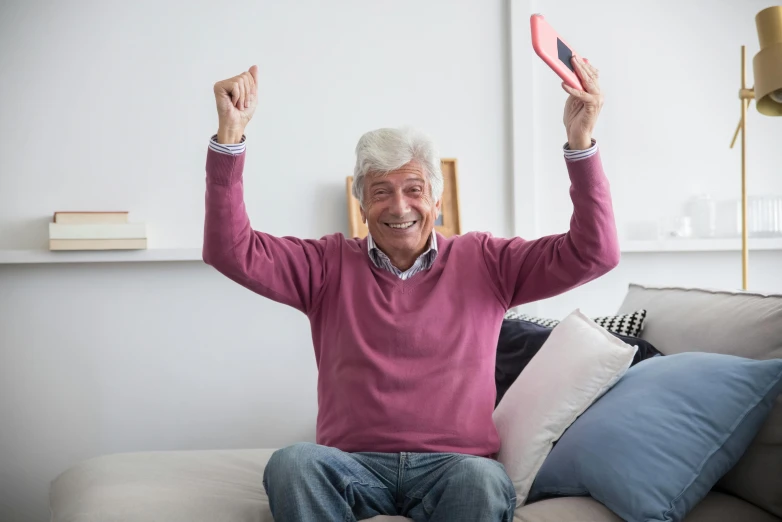 an elderly man holding two hands up