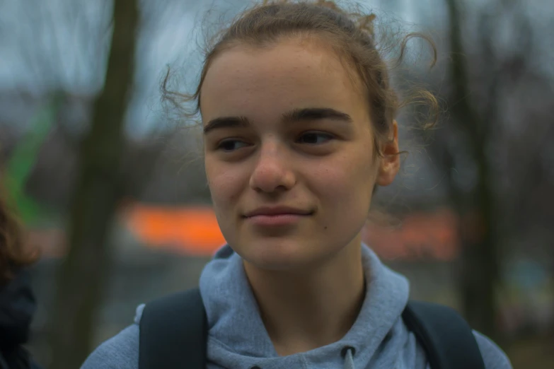 a close up of a person with a backpack, a character portrait, by Emma Andijewska, pexels contest winner, antipodeans, chilled out smirk on face, teenage girl, detailed unblurred face, proud smirk