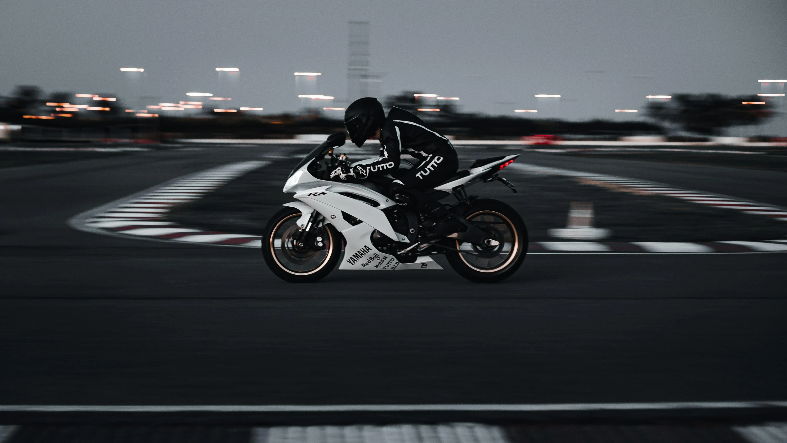 a man riding on the back of a white motorcycle on a street