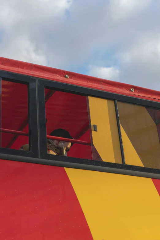 the person is in a striped bus looking out