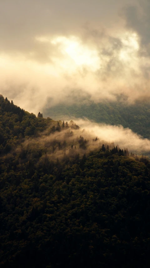 there is a tall mountain that has a large amount of clouds