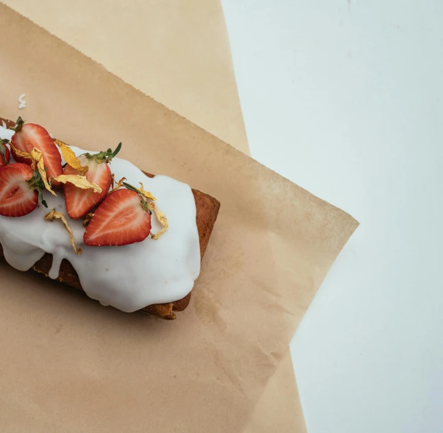 a pastry sitting on top of a piece of paper, inspired by Richmond Barthé, trending on unsplash, minimalism, strawberry fields forever, rectangle, ignant, manuka