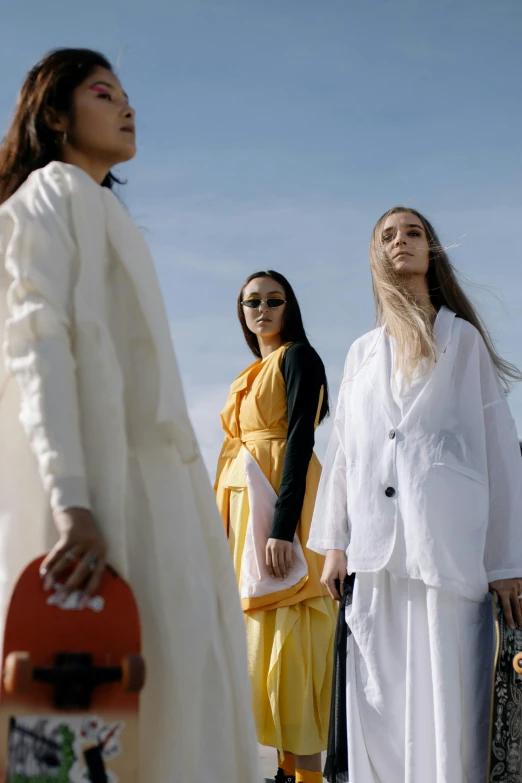 a group of women standing next to each other, trending on unsplash, gutai group, wearing off - white style, video, at a fashion shoot, on a bright day