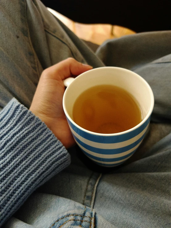 a person holding a cup of liquid