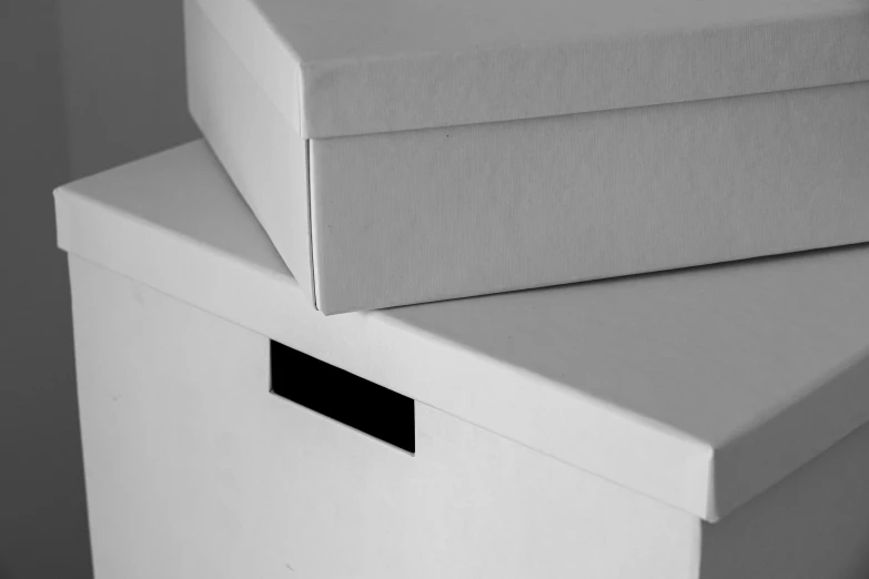 two boxes are stacked on top of each other, a black and white photo, by John Hutton, unsplash, photorealistic detail, soft white rubber, letterbox, studio product shot