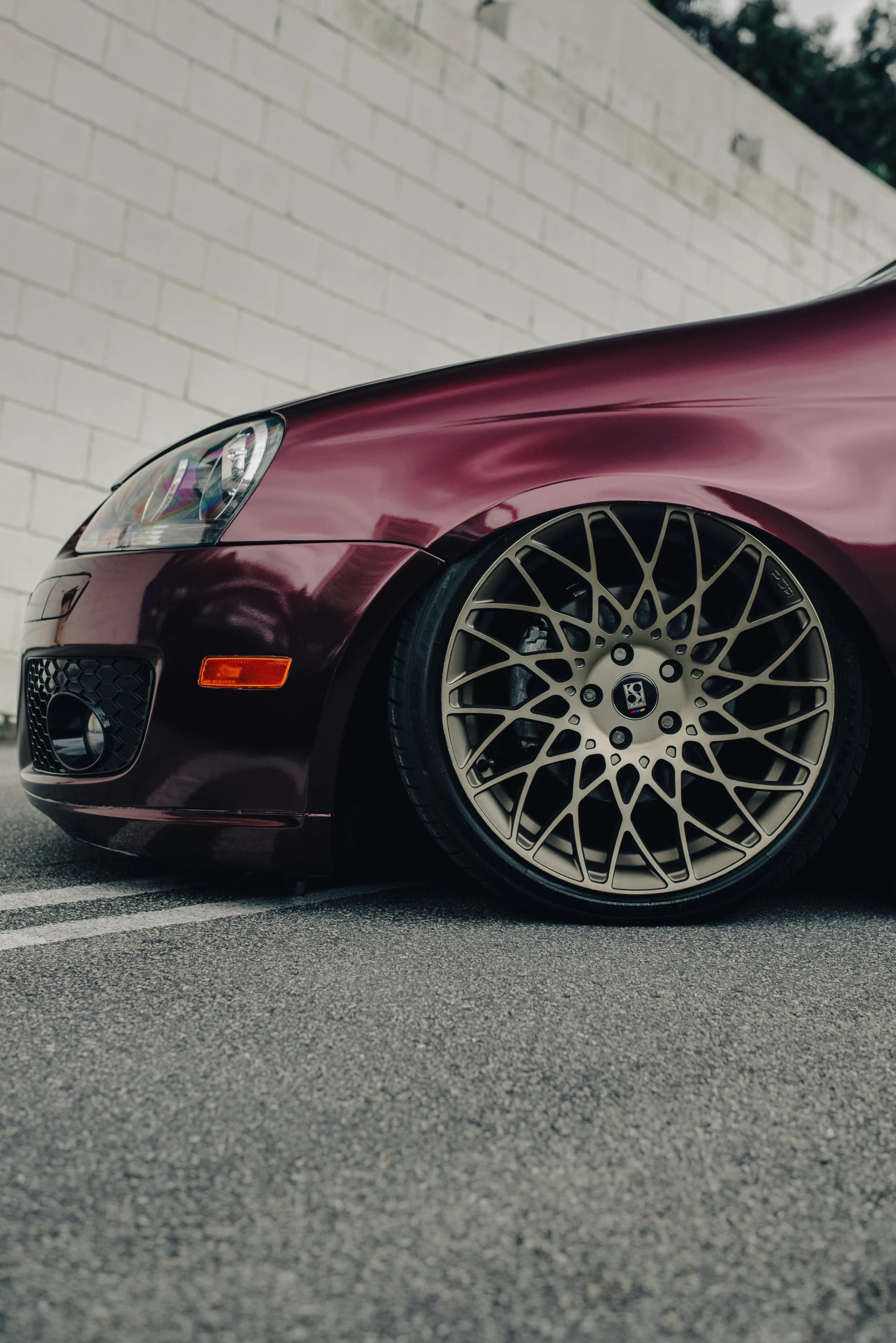 a maroon car parked on the side of the road, detailed alloy wheels, arcs, portrait photo, performance