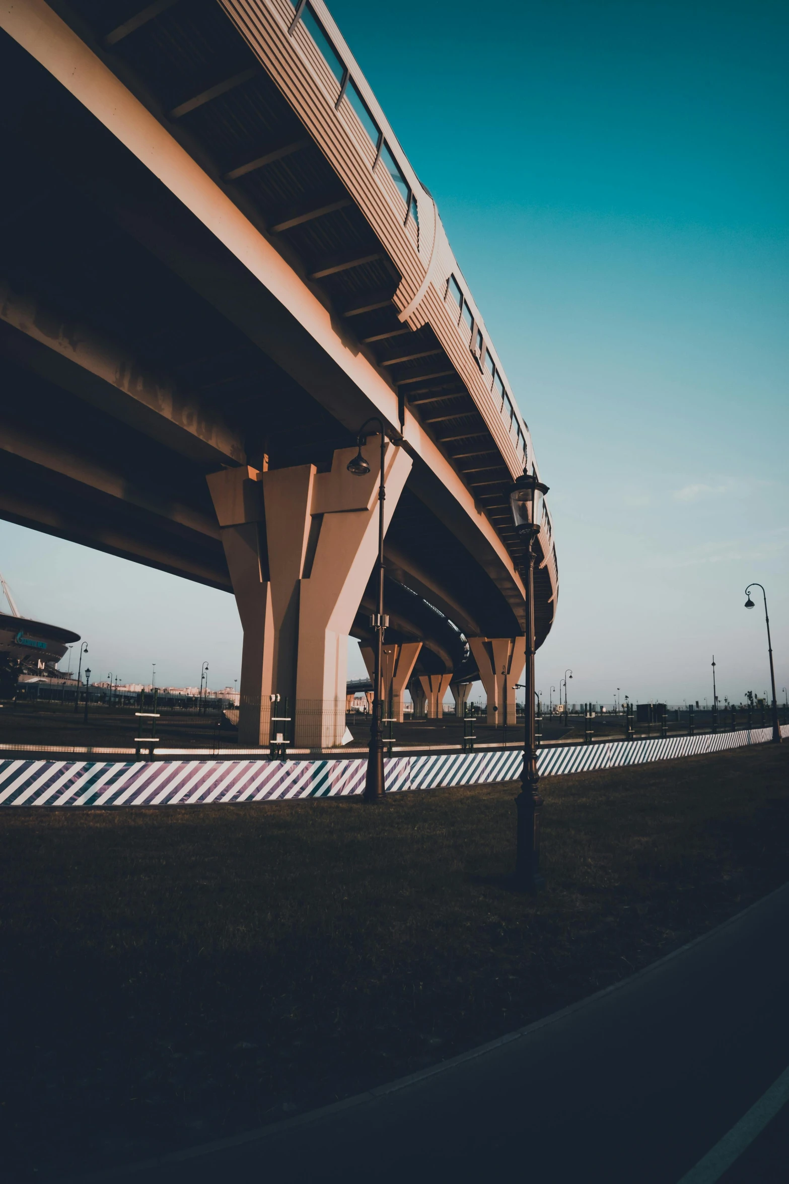 a train that is going over a bridge, by Austin English, unsplash contest winner, street corner, concrete pillars, freeway, sitting down