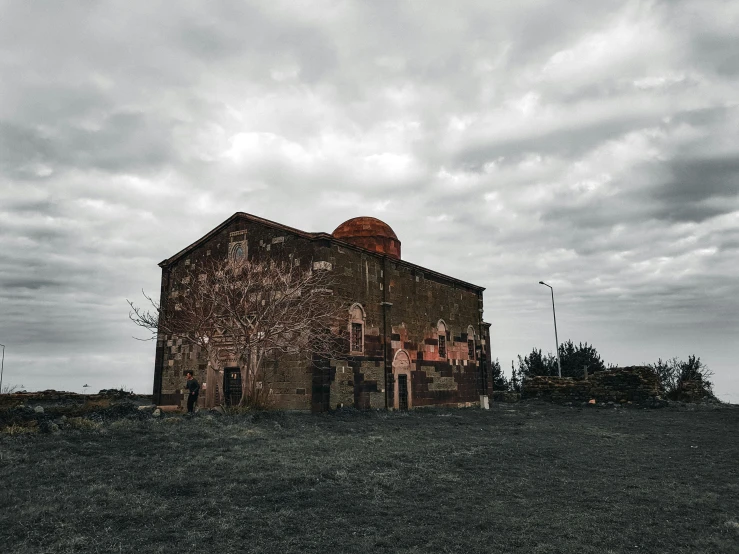 a building sitting on top of a lush green field, by Lucia Peka, pexels contest winner, renaissance, gloomy medieval background, ((rust)), byzantine, sad sky