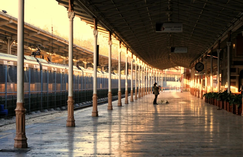 a train pulling into a train station next to a platform, pexels contest winner, arabesque, lonely human walking, late afternoon, preserved historical, sayem reza