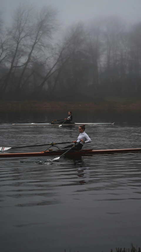 a couple of men rowing across a body of water, foggy day outside, low quality photo, winning photo, 2263539546]