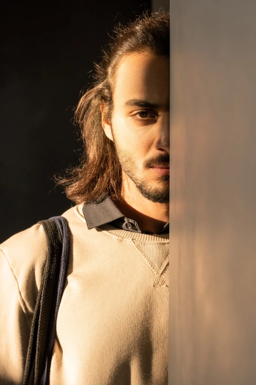 a man holding on to a wall with his hand over his shoulder