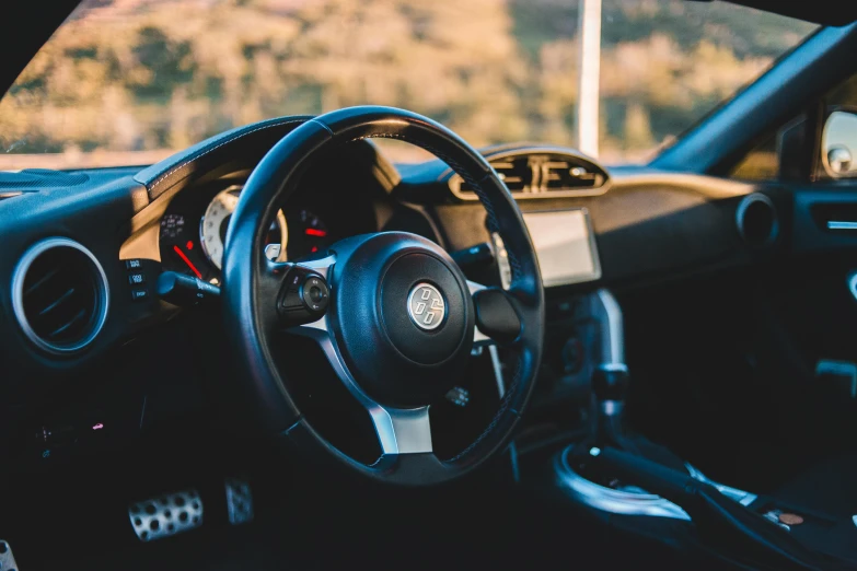 a close up of a steering wheel in a car, by Carey Morris, unsplash, toyota supra, beautiful environment, rectangle, 2015 alfa romeo 4c