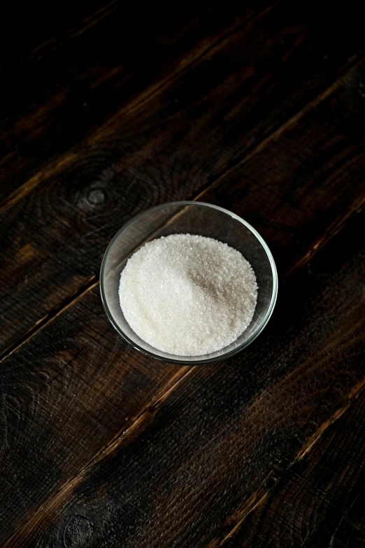 a bowl of sugar sitting on top of a wooden table, detailed product image, crust, paul barson, yeast