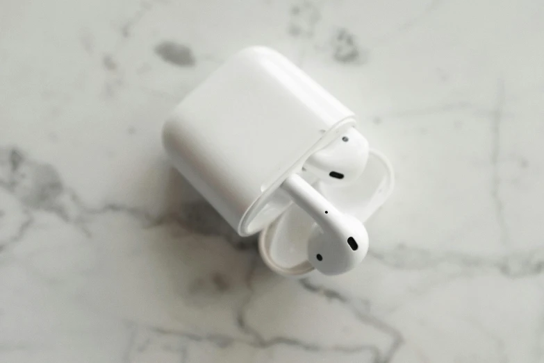 an apple airpods sitting on a marble surface, by Carey Morris, pexels, square, white plastic, 1 2 9 7, dual tone