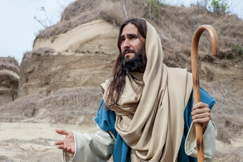 a man that is standing in the dirt with a stick, pexels, renaissance, dressed like jesus christ, avatar image, hills, [ theatrical ]