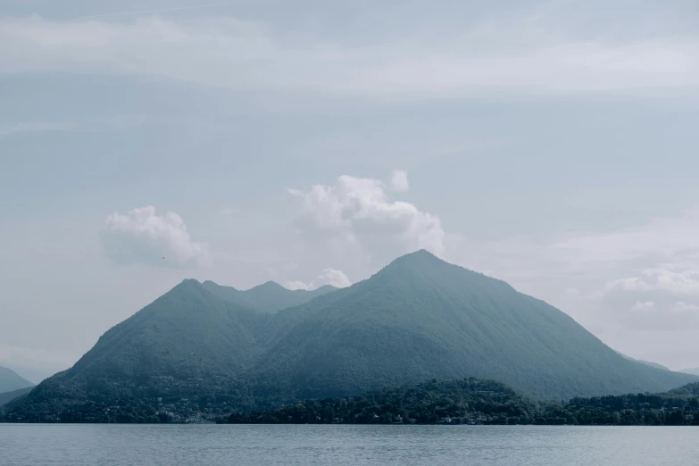 mountains and trees in the water next to a shore